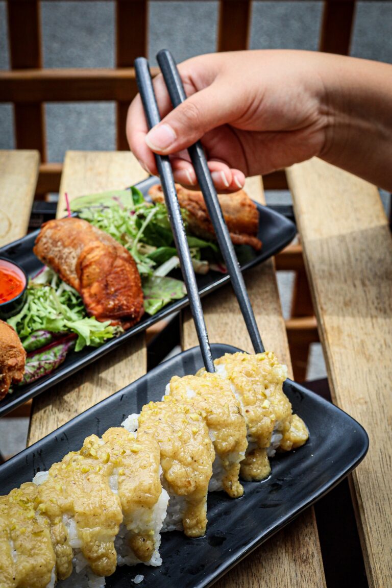 Détail de sushis pris aux baguettes