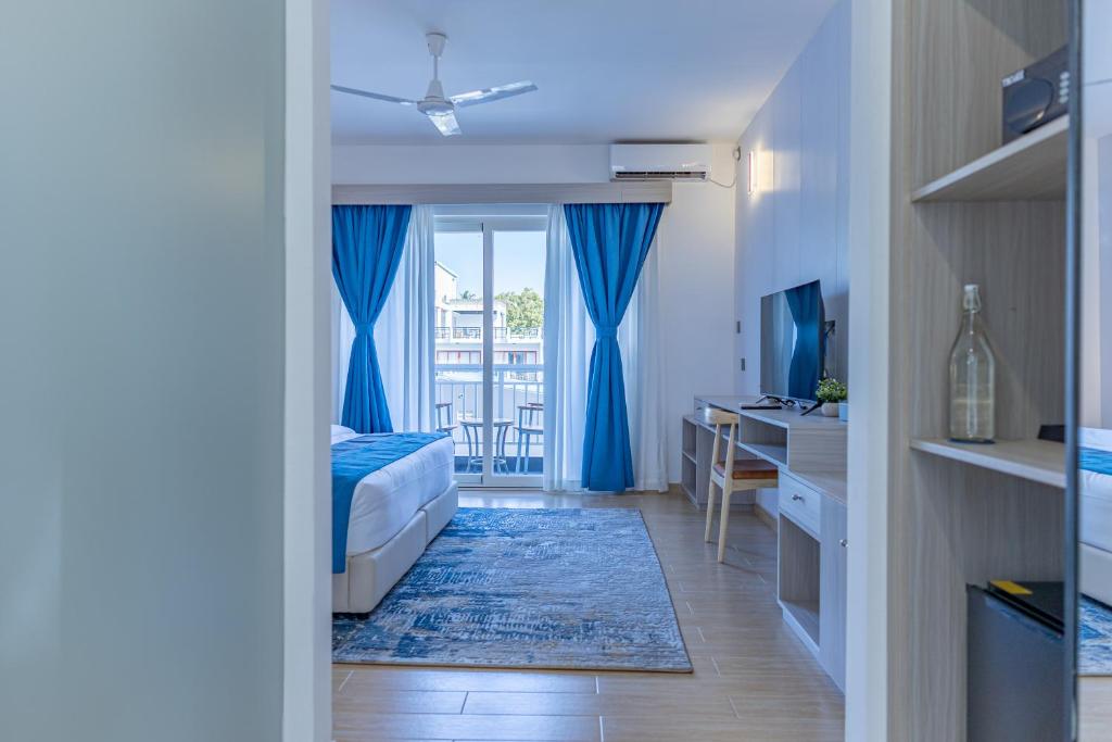 Chambre lumineuse aux rideaux bleus au Dhiguveli Maldives, Dhigurah