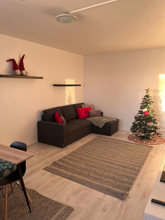 Salon du Kaamos Apartment à Rovaniemi avec canapé d'angle et sapin de Noël