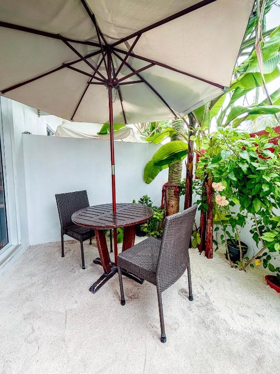 Terrasse privative sur le sable avec parasol au The Wave Dhigurah