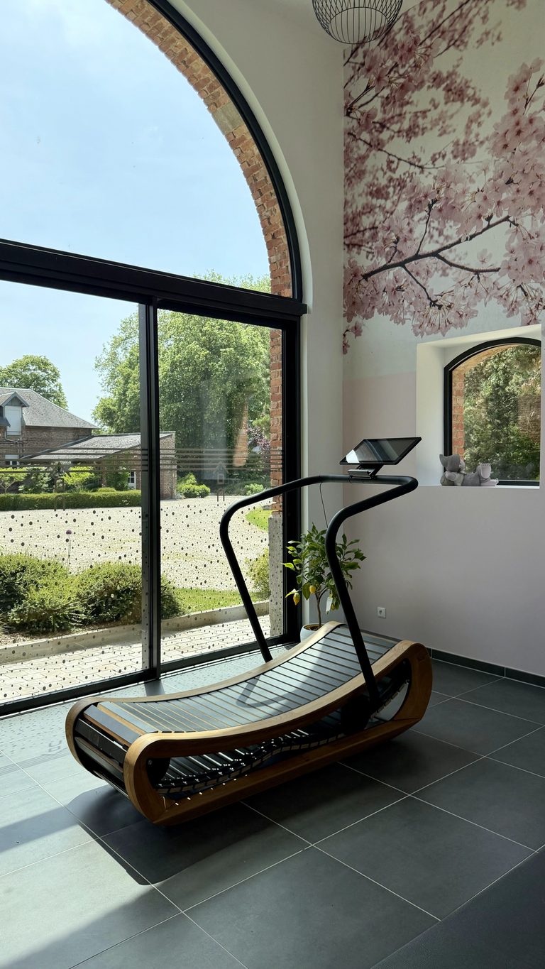 Salle de sport avec grande baie vitrée au gîte de la Ferme de Sorval