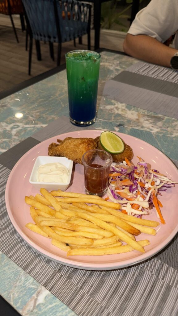 Assiette de poulet pané, frites et crudités dans un restaurant aux Maldives