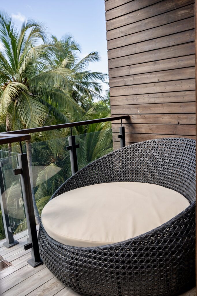 Balcon avec fauteuil en rotin au Beach Hotel à Dhigurah