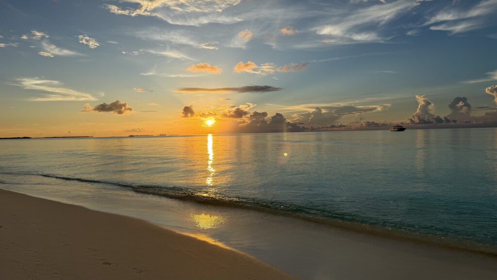 Coucher de soleil sur la plage de sable blanc de Dhigurah, aux Maldives, avec le lagon calme