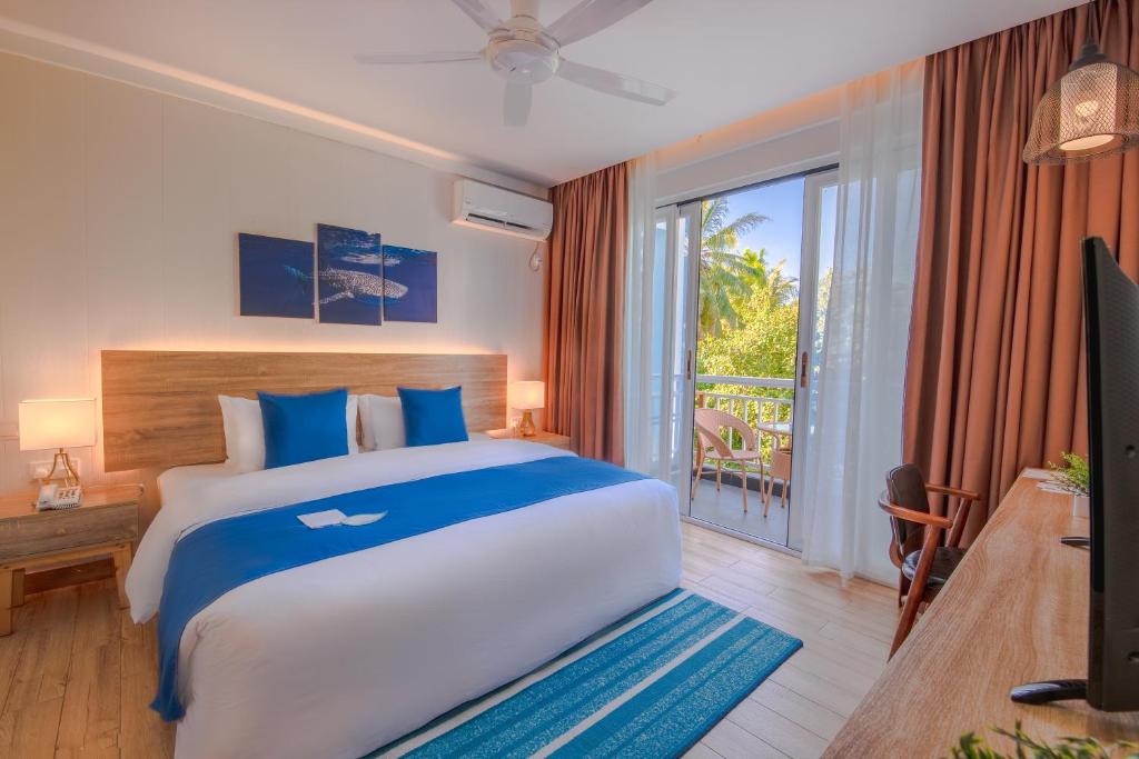 Chambre avec lit king size et balcon au Dhiguveli Maldives, à Dhigurah