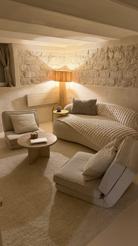 Salon cosy aux murs en pierre éclairés, La Grotte Vernon