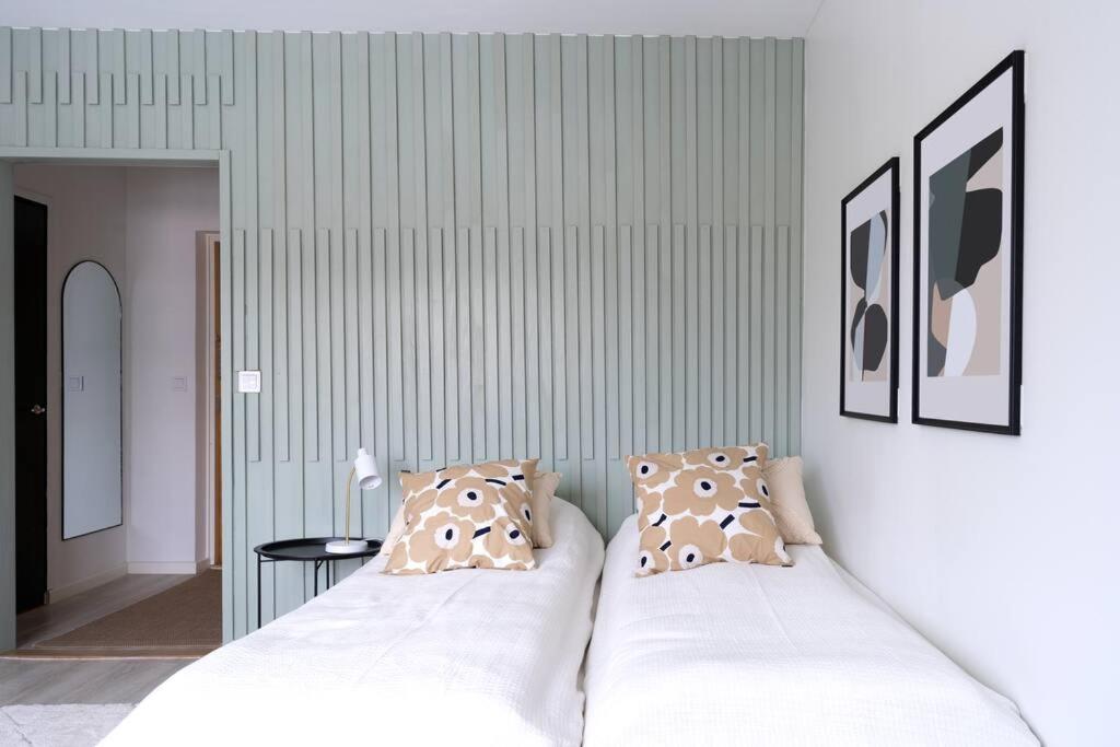 Chambre avec lits et mur en lames vert sauge au Lapland's Little Retreat à Rovaniemi