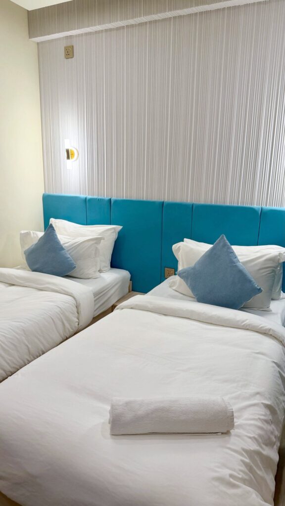Lits jumeaux et coussins bleus au Six Beach Hotel à Hulhumalé