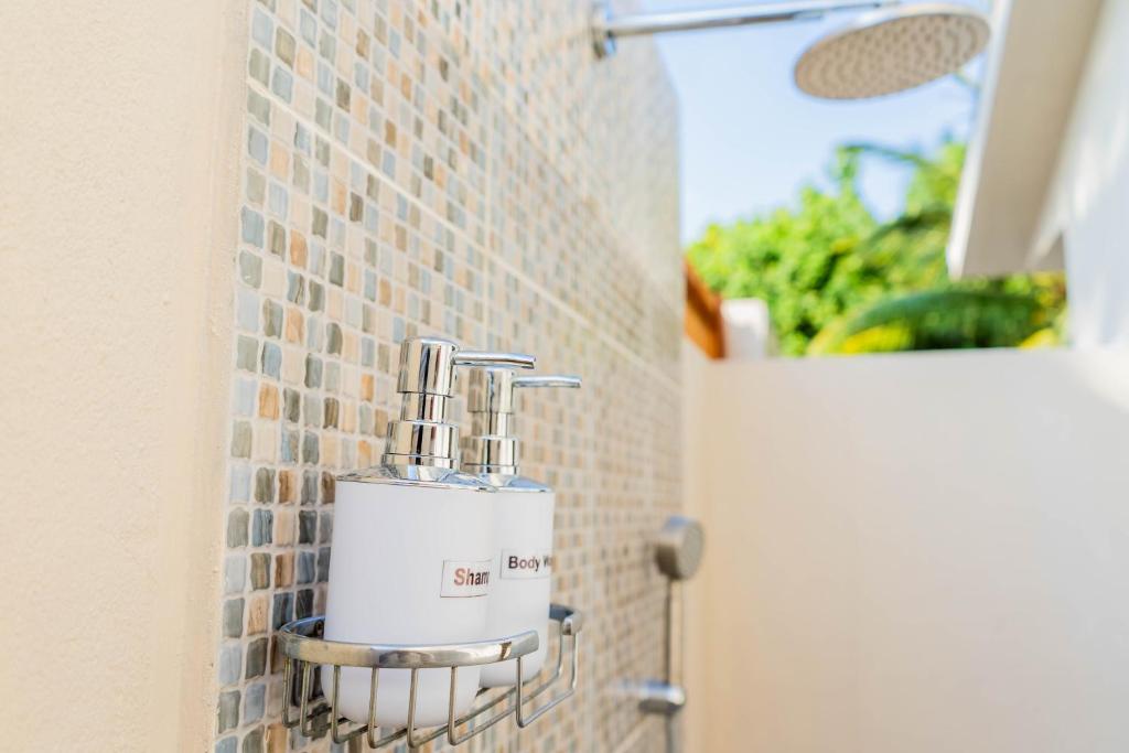 Douche extérieure en mosaïque ouverte sur la végétation tropicale au Pearl Dhigurah