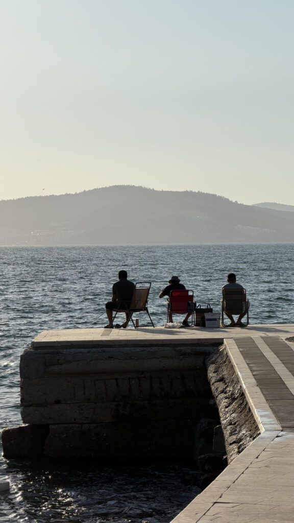 Personnes assises sur le ponton du village de pêcheurs de Gülük, Bodrum