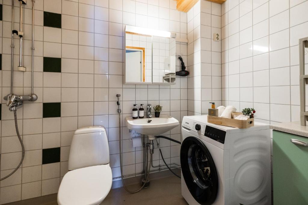 Salle de bains avec douche et lave-linge au Rovaniemi City Center Apartment