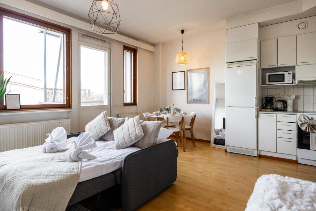 Séjour lumineux avec canapé-lit, coin repas et cuisine équipée au Rovaniemi City Center Apartment