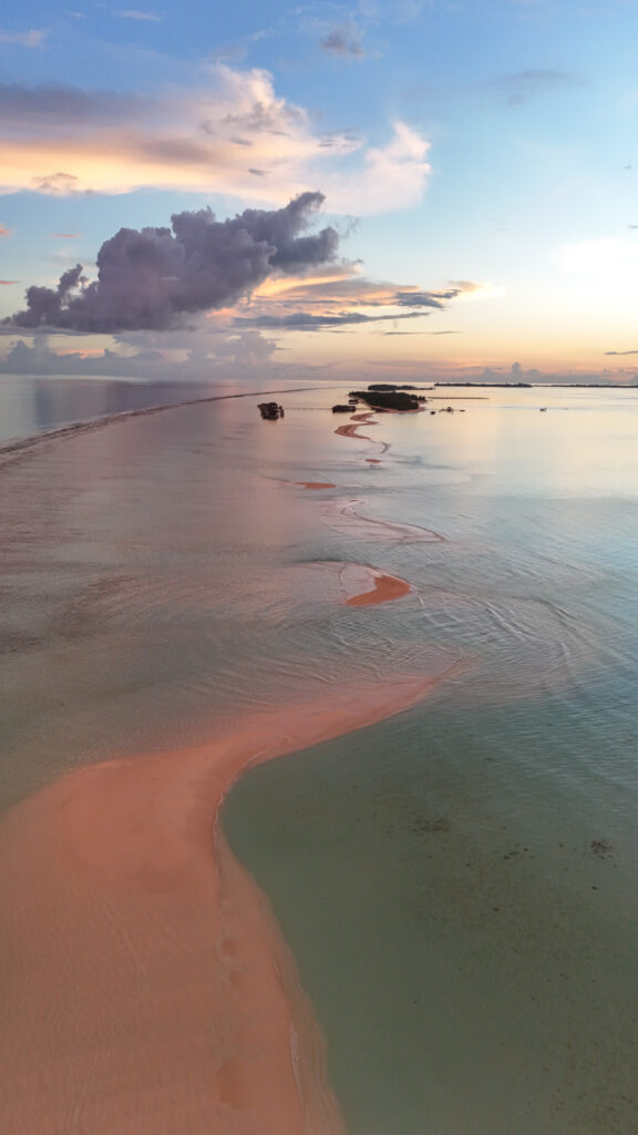 Vue drone du sandbank de Dhigurah aux Maldives, une langue de sable qui serpente dans le lagon au coucher du soleil