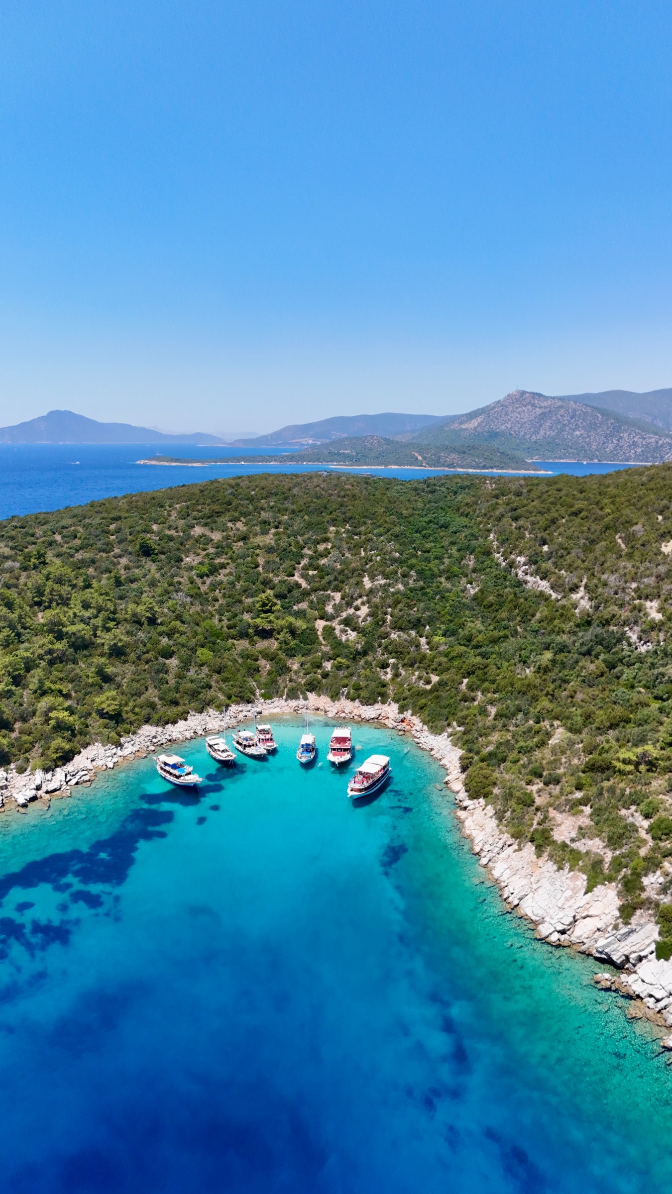 Vue aérienne de la crique turquoise de l'île d'Orak avec des bateaux au mouillage