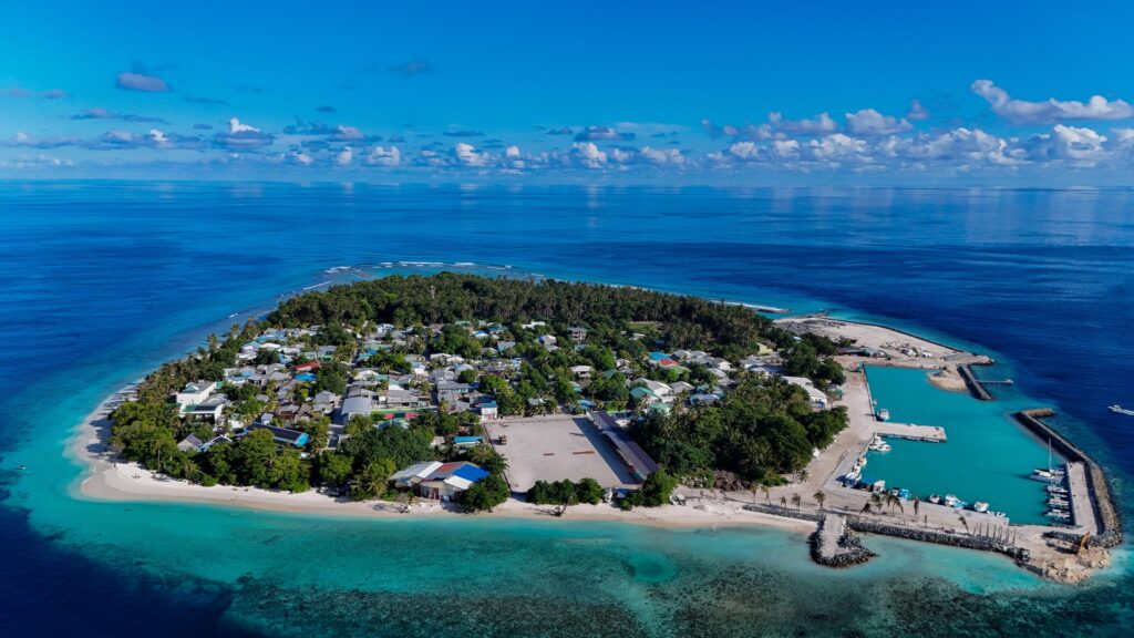 Vue aérienne d'une île locale des Maldives entourée de son lagon turquoise